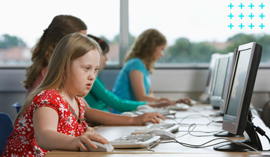 Crianças diversas mexendo nos computadores na sala de informática.