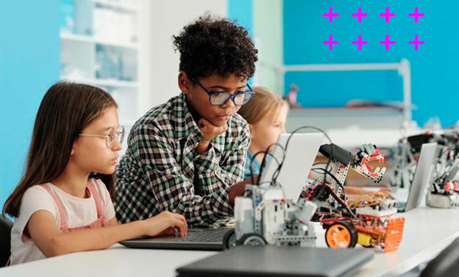 grupo de três crianças diversas composto por duas meninas e um menino aprendem sobre robótica na sala de aula.