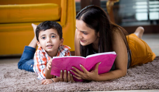 mãe lendo deitada com o filho.