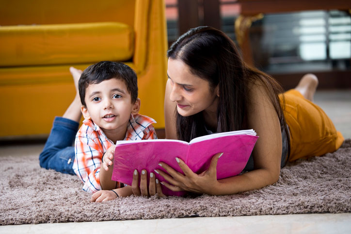mãe lendo deitada com o filho.