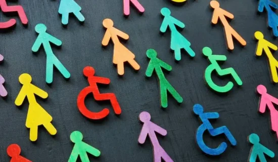 Imagem com figuras de papel coloridas representando diversidade e inclusão, incluindo símbolos de acessibilidade para pessoas com deficiência, em fundo escuro.